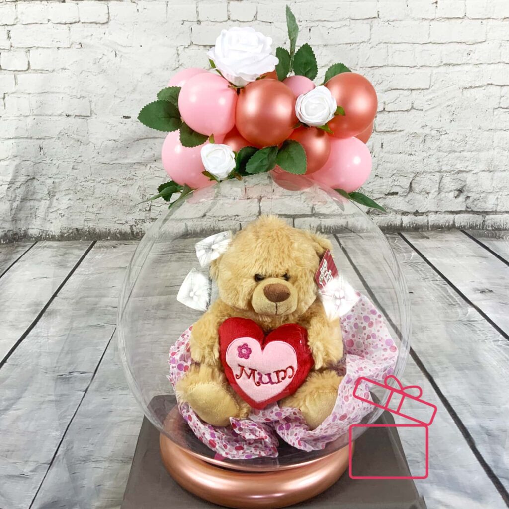 Adorable Surprise: Mother's Day Clear Balloon with Teddy Bear Inside Introducing our enchanting Mother's Day surprise: a Clear Balloon adorned with a cuddly Teddy Bear, topped with delicateflowers and balloons.